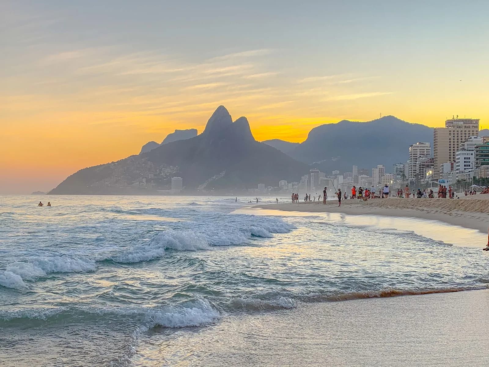 Waves at Ipanema beach with Dois Irmãos at sunset
