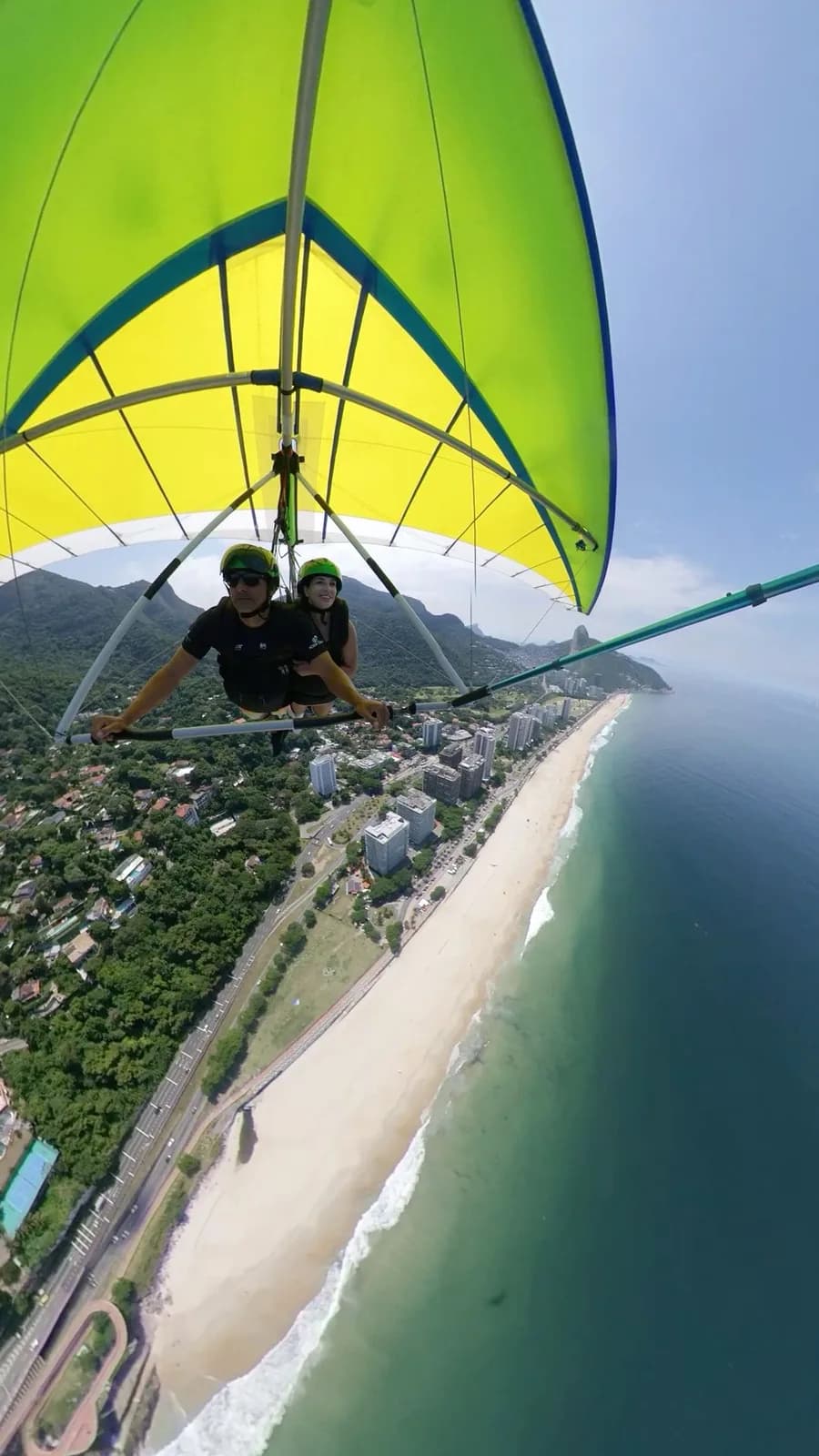 Tandem hang glider soaring above the São Conrado shoreline