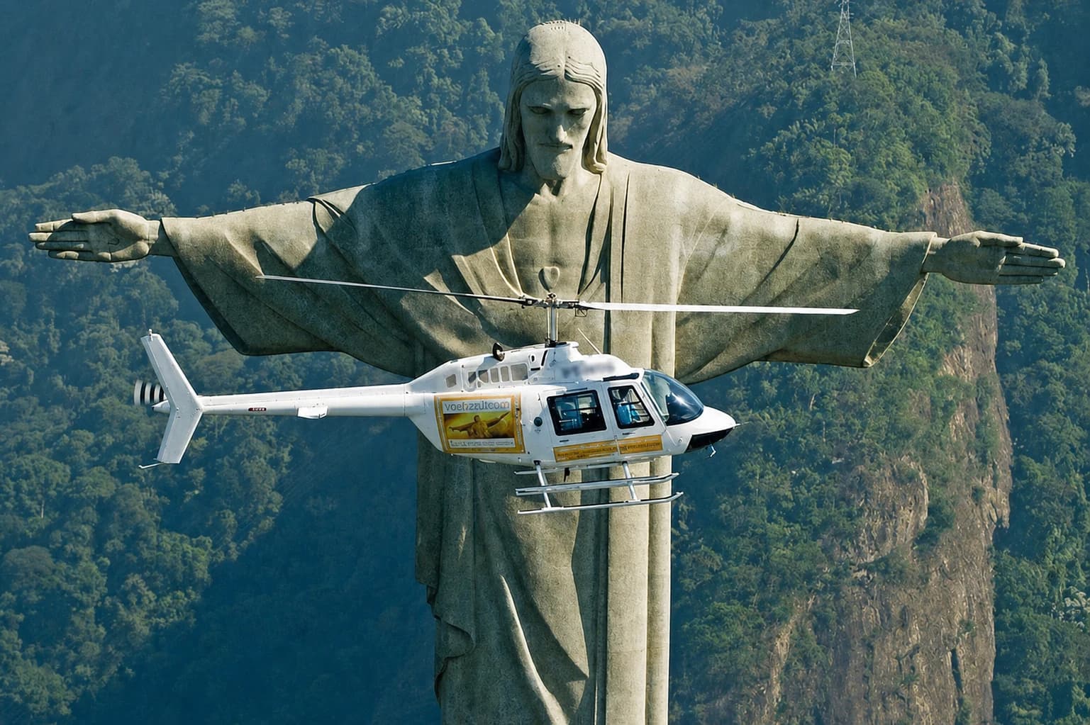 A helicopter flying in front of Christ the Redeemer